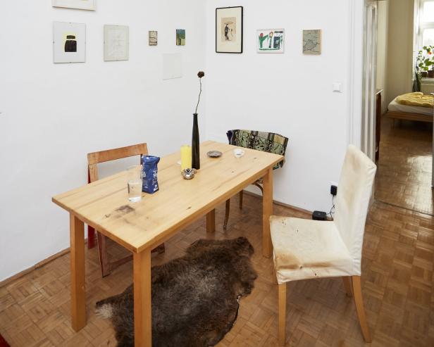 Ein Esstisch mit Stühlen in einem Zimmer mit Kunst an den Wänden.