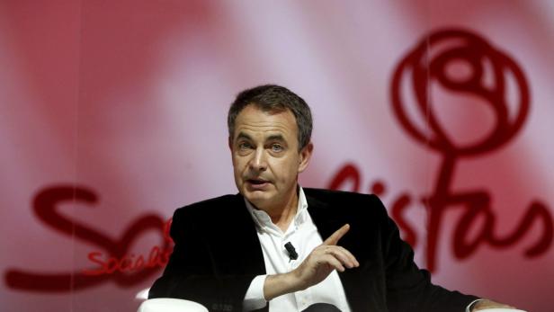José Luis Rodríguez Zapatero spricht vor einem roten Hintergrund mit dem Logo der spanischen sozialistischen Partei.