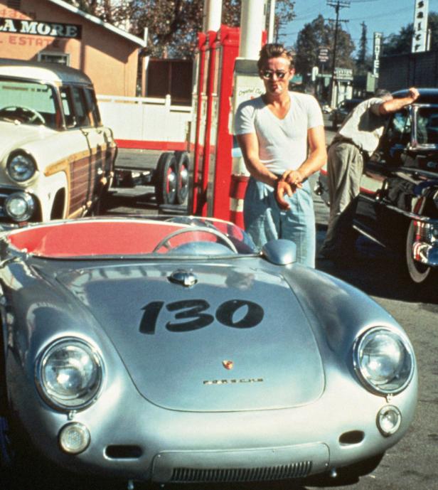 James Dean steht an einer Tankstelle neben seinem Porsche 550 Spyder mit der Startnummer 130.