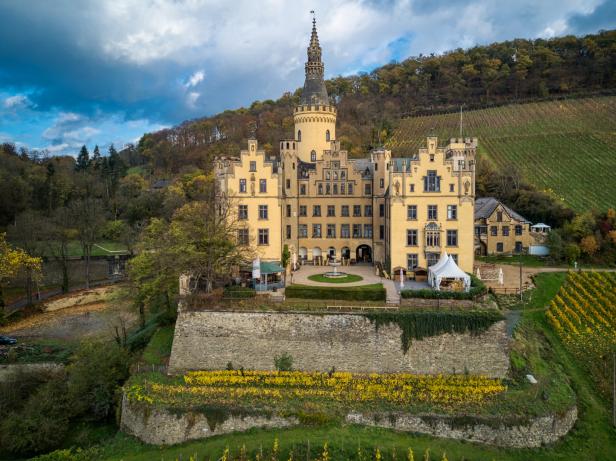 Schloss Johannisberg thront auf einem Hügel, umgeben von Weinbergen.