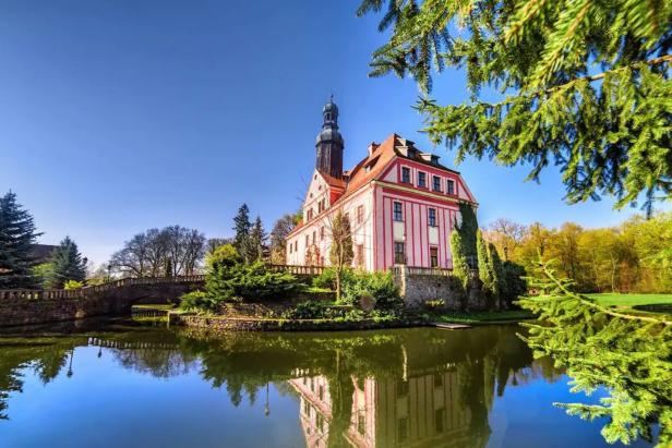 Schloss Rackwitz spiegelt sich im Wassergraben.