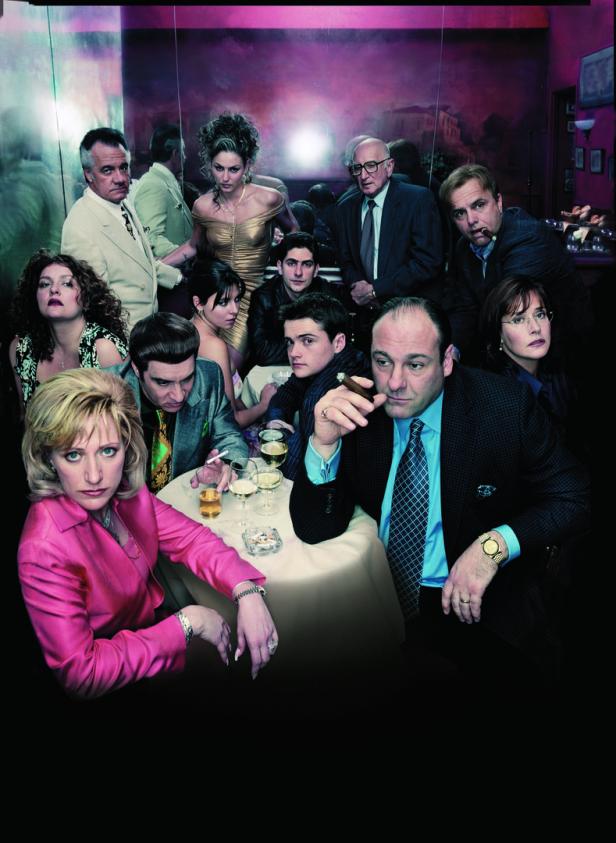 Die Besetzung der Fernsehserie „Die Sopranos“ sitzt an einem Tisch in einem Restaurant.