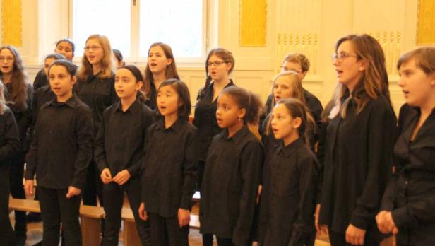 Ein Jugendchor singt in einem hellen Raum.