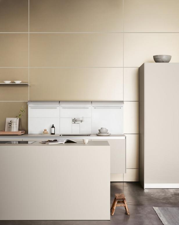 Eine moderne Küche in neutralen Farben mit Kochinsel und minimalistischem Design.