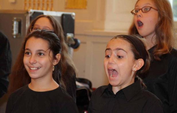 Eine Gruppe junger Mädchen singt in einem Chor.