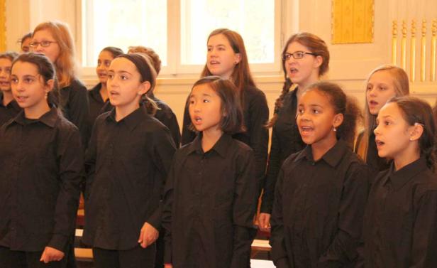Ein Kinderchor singt in schwarzen Hemden.