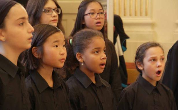Eine Gruppe junger Mädchen singt in einem Chor.