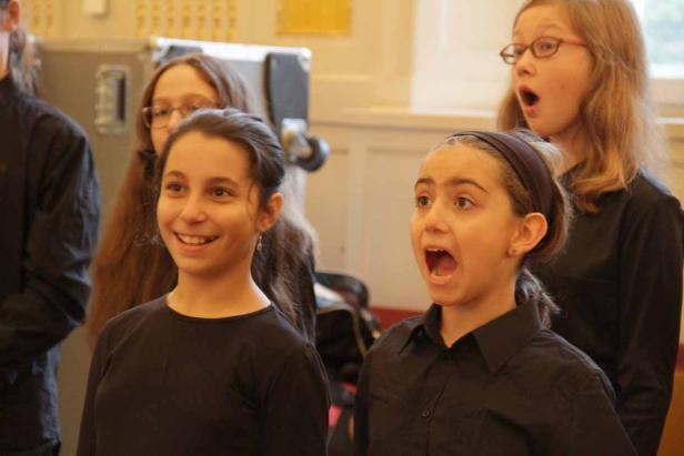 Einige junge Mädchen singen in einem Chor.