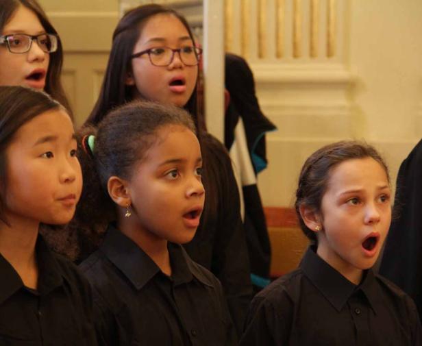 Eine Gruppe junger Mädchen singt in einem Chor.