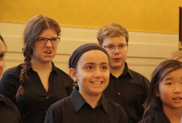 Eine Gruppe junger Menschen, vermutlich ein Chor, singt gemeinsam.