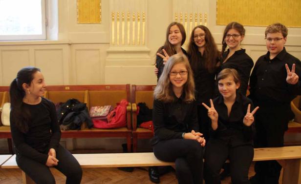 Eine Gruppe Jugendlicher posiert lächelnd für ein Foto.