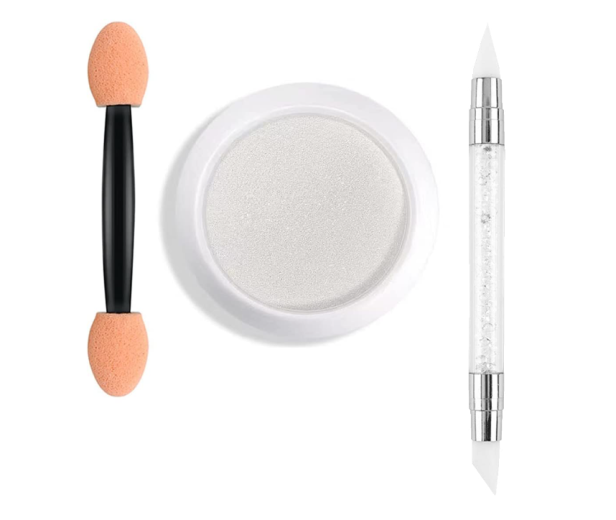Ein Döschen mit schimmerndem Puder, ein Applikator und ein Silikonwerkzeug für Nageldesign.