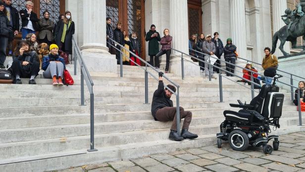 A student in a wheelchair is looking for ideas for a barrier-free main entrance to the university