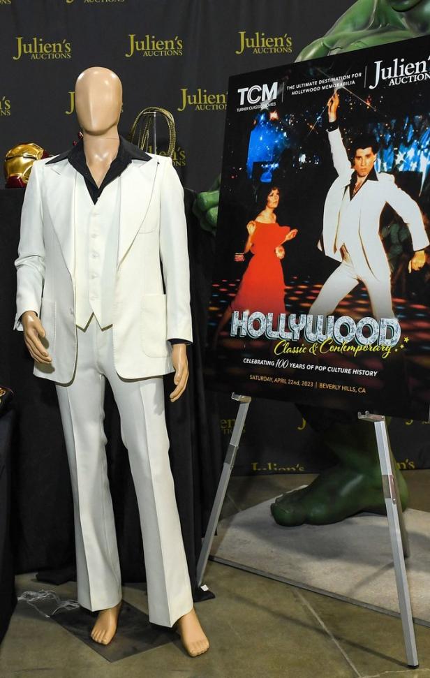Ein Schaufensterpuppe trägt einen weißen Anzug neben einem Poster für eine „Hollywood Classic & Contemporary“-Auktion.