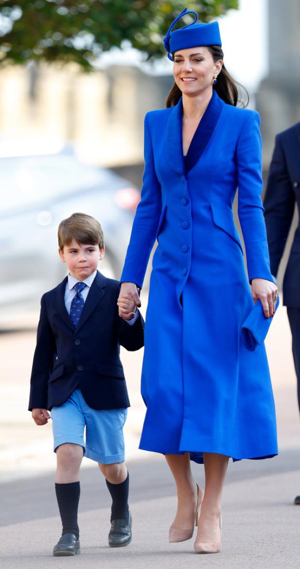 Kate Middleton und Prinz Louis Hand in Hand in passenden blauen Outfits.