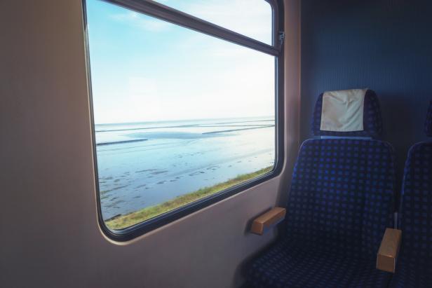 Blick aus einem Zugfenster auf das Wattenmeer.