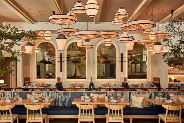Ein elegant eingerichtetes Restaurant mit Tischen, Stühlen und dekorativen Lampen.