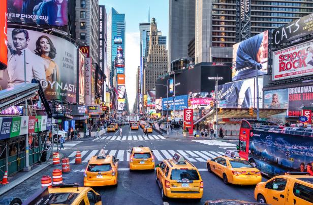 Der Times Square in New York City mit gelben Taxis und vielen Werbetafeln.