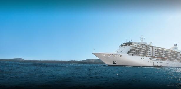 Die „Seven Seas Voyager“ kreuzt auf dem Meer unter blauem Himmel.
