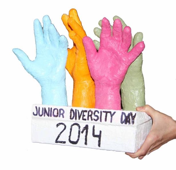 Ein Modell zum „Junior Diversity Day 2014“ mit bunten Händen, das von einer Hand gehalten wird.