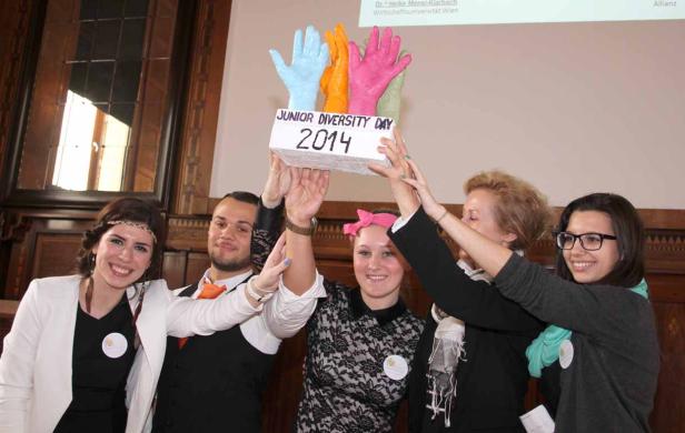 Eine Gruppe junger Leute hält eine Trophäe mit der Aufschrift „Junior Diversity Day 2014“ hoch.