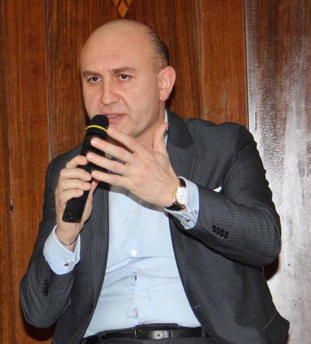 Ein Mann im Anzug spricht in ein Mikrofon.