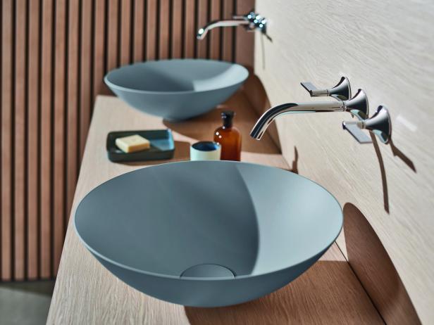 Zwei graue Aufsatzwaschbecken mit Armaturen in einem modernen Badezimmer.
