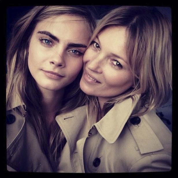 Cara Delevingne und Kate Moss posieren zusammen in Trenchcoats.