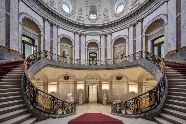 Das Innere des Bode-Museums in Berlin mit einer geschwungenen Treppe und Statuen.
