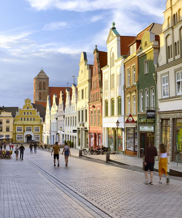 Eine belebte Straße mit historischen Gebäuden in Wismar, Deutschland.