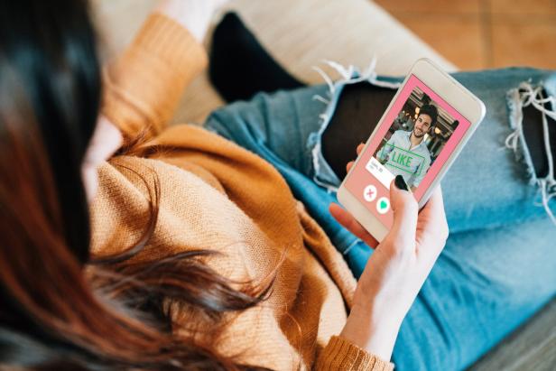 Eine Frau wischt auf einer Dating-App auf ihrem Smartphone nach rechts.