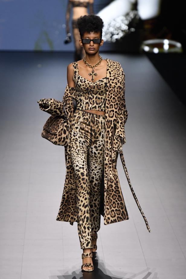 Eine Frau auf dem Laufsteg, gekleidet in ein Leopardenmuster-Ensemble mit passender Handtasche.