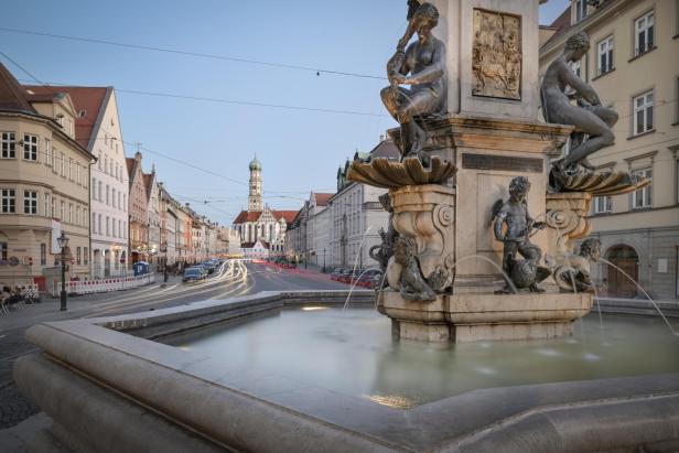 Der Herkulesbrunnen in Augsburg mit der St.-Anna-Kirche im Hintergrund.