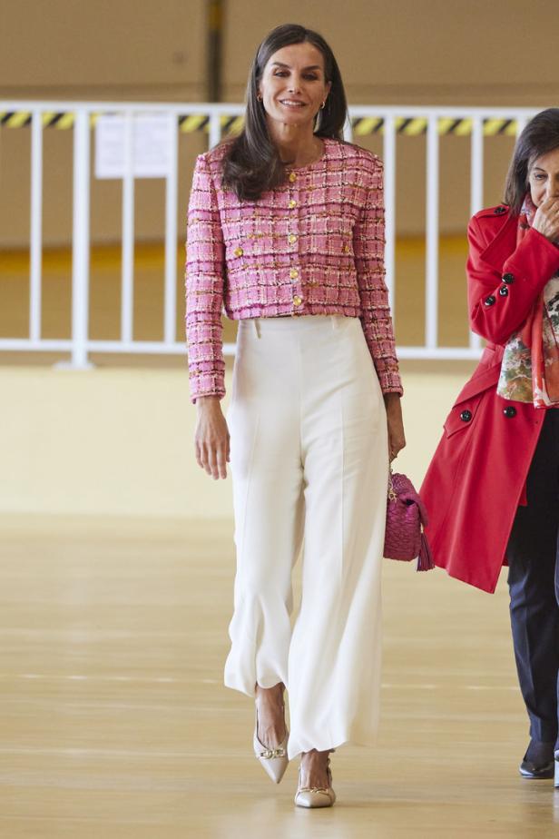 Königin Letizia trägt ein rosa Tweed-Jackett und eine weiße Hose.