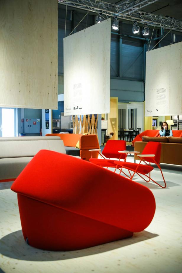 Ein Ausstellungsraum mit modernen Möbeln in Rot, Orange und Grau.