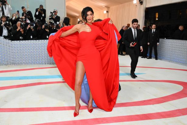Kylie Jenner in einem roten Kleid mit Schleppe auf dem roten Teppich.