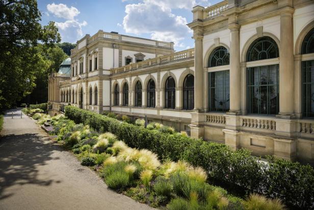 Der Luitpoldbau in Bad Kissingen, ein UNESCO-Weltkulturerbe, mit gepflegten Gärten im Vordergrund.