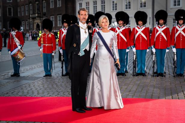 Prinz Joachim und Prinzessin Marie von Dänemark auf einem roten Teppich, umgeben von Gardesoldaten.