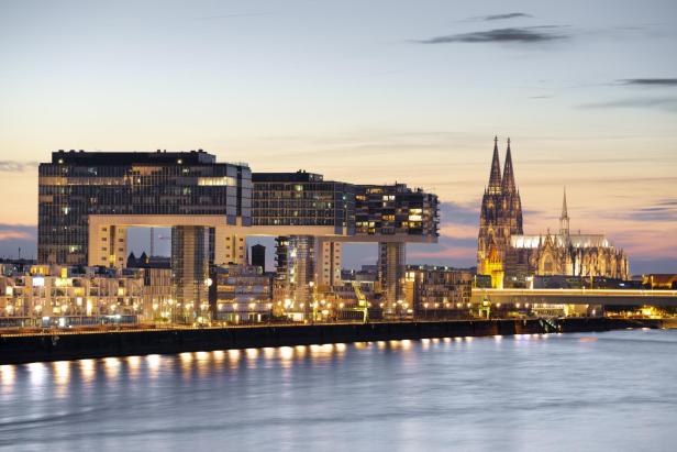 Die Kölner Skyline mit dem Kölner Dom und den Kranhäusern am Rhein bei Dämmerung.