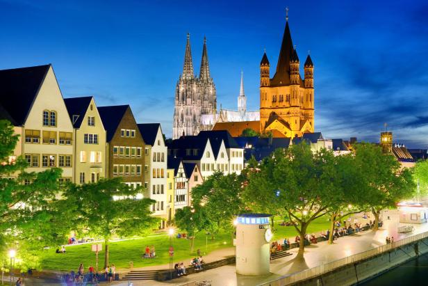 Blick auf die Kölner Altstadt mit dem Kölner Dom und Groß St. Martin im Abendlicht.