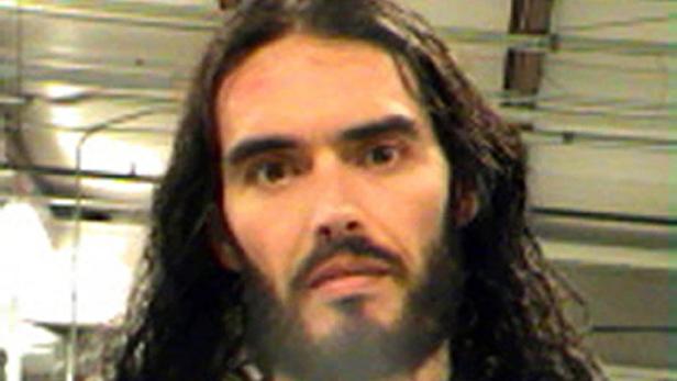 Porträt von Russell Brand mit langen, dunklen Haaren und Bart.