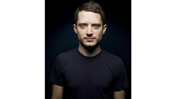 Ein Porträt von Elijah Wood vor einem dunklen Hintergrund.
