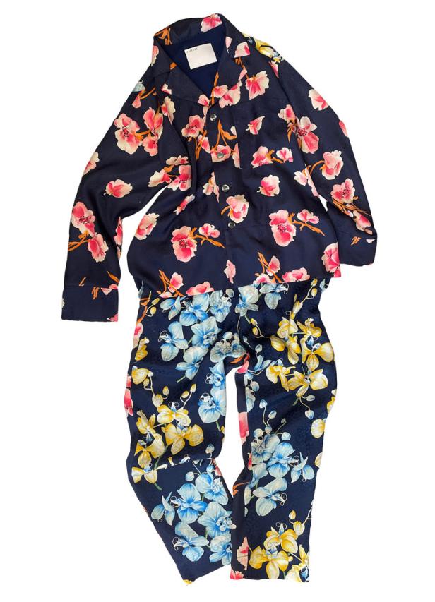 Ein marineblauer Pyjama mit einem Blumenmuster in Rosa, Gelb und Blau.