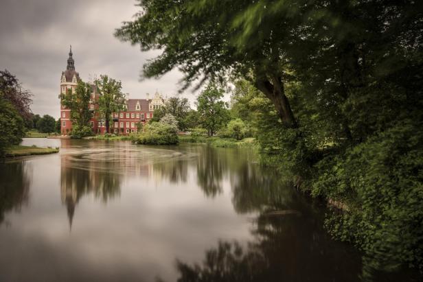 Das Schloss Muskau spiegelt sich im Wassergraben.