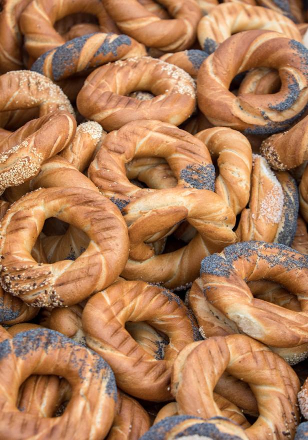 Ein Haufen goldbrauner Brezeln, einige mit Sesam und andere mit Mohn bestreut.
