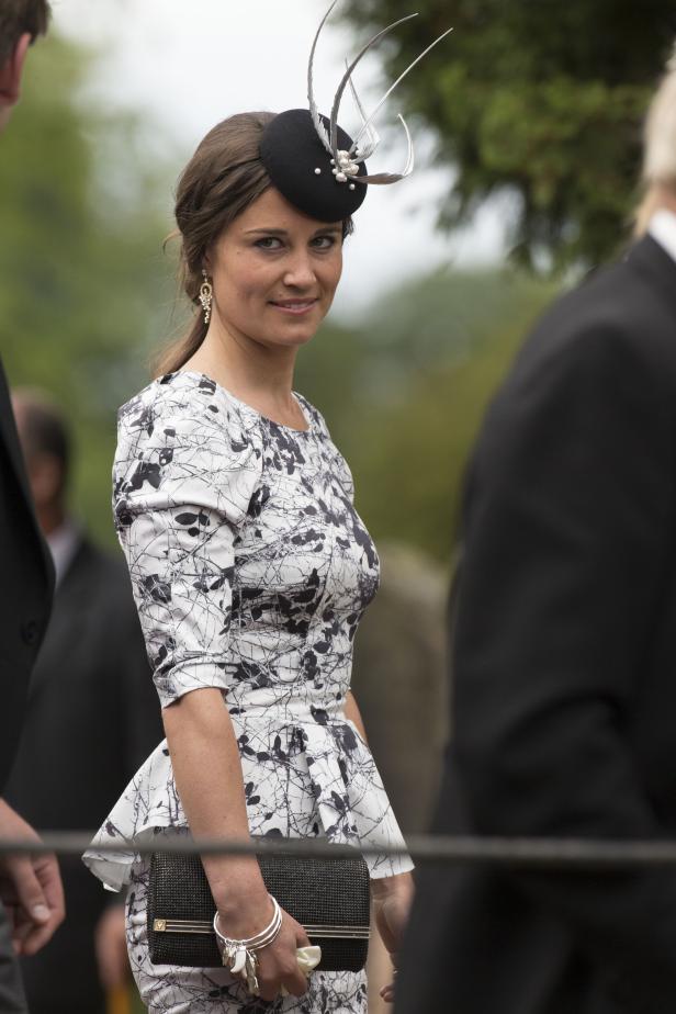 Pippa Middleton mit einem gemusterten Kleid und einem Hut mit Federn.