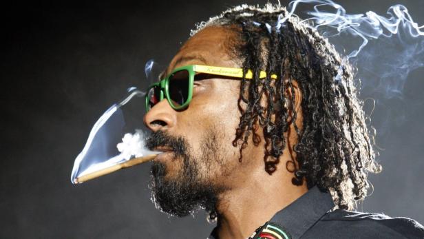 Snoop Dogg mit grüner Sonnenbrille raucht einen Joint.