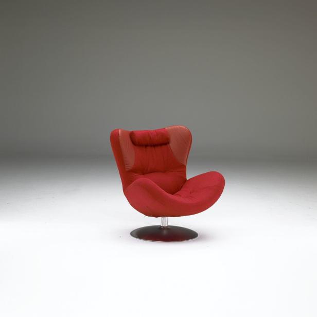 Ein roter Sessel mit Kopfstütze steht auf einem Drehteller.
