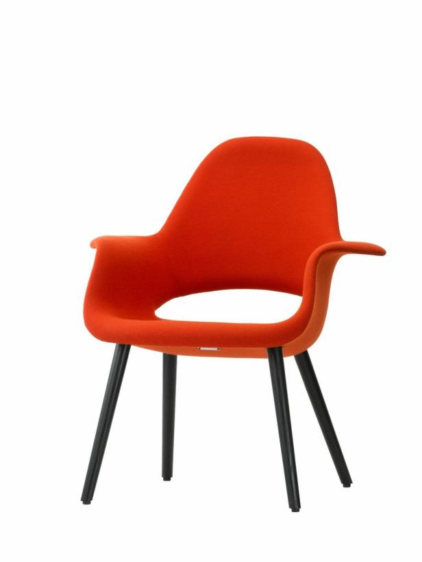 Ein orangefarbener Sessel mit schwarzen Beinen vor einem weißen Hintergrund.