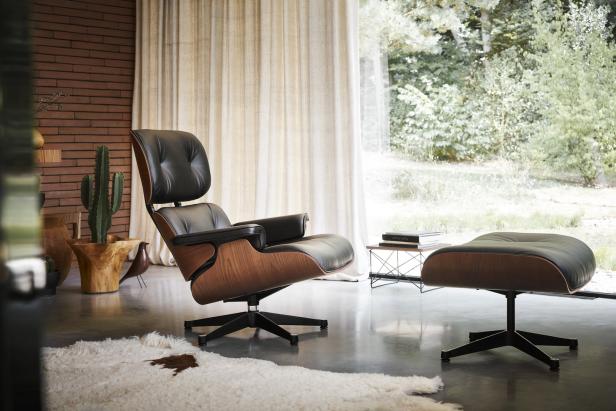 Ein schwarzer Ledersessel mit Fußhocker in einem modern eingerichteten Wohnzimmer.